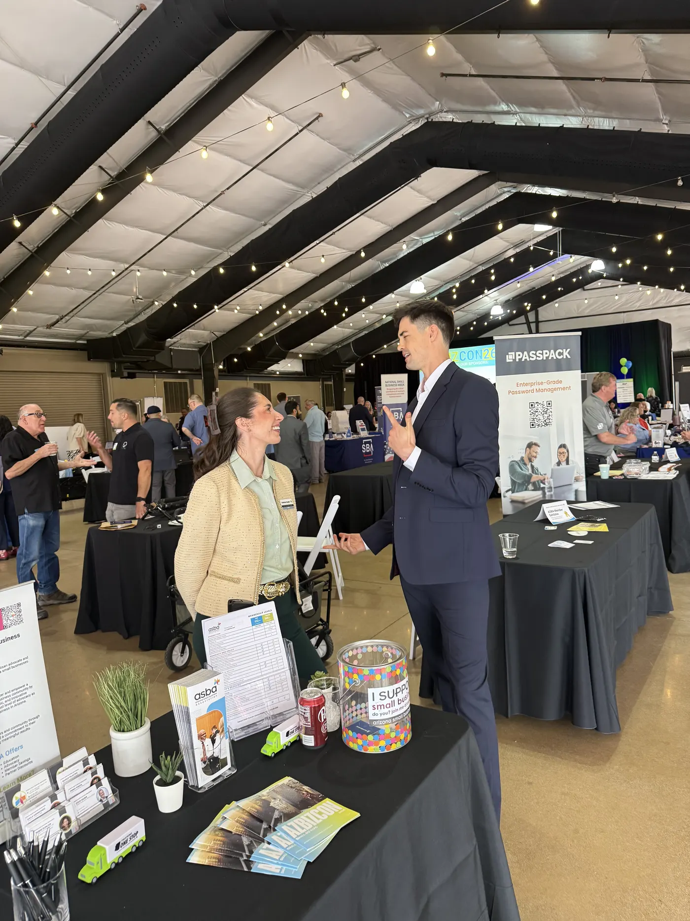 A busy AZBIZCON exhibit hall, with visitors talking at the sponsor tables