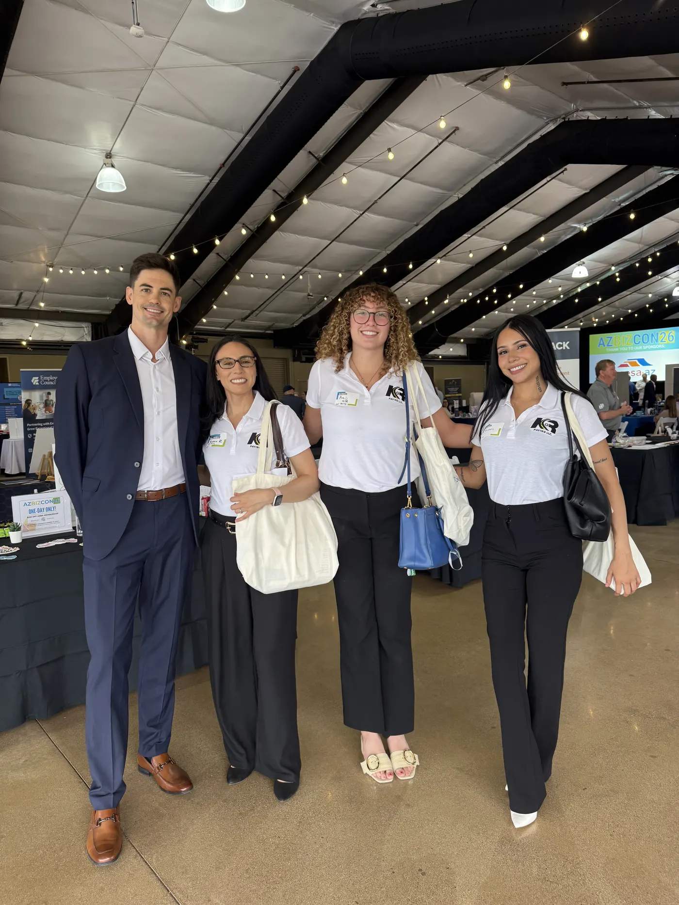 Four people standing together on the AZBIZCON 2026 conference floor